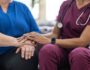Nurse holding her patient's hand.