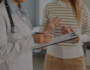 Doctor with a clipboard speaking to a patient- tinted